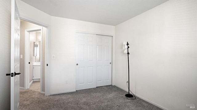 unfurnished bedroom featuring light carpet and a closet