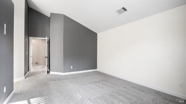 carpeted spare room with lofted ceiling