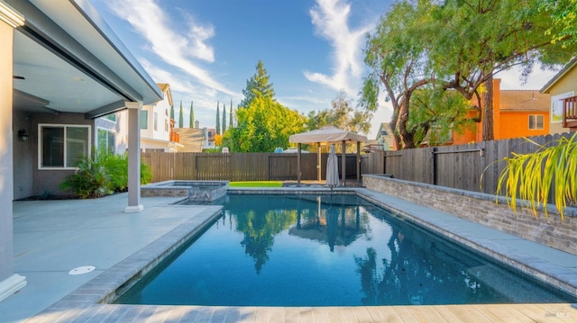 view of swimming pool featuring a fenced backyard, a pool with connected hot tub, and a patio area