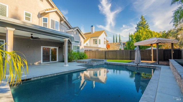 view of swimming pool with ceiling fan, a patio area, and an in ground hot tub