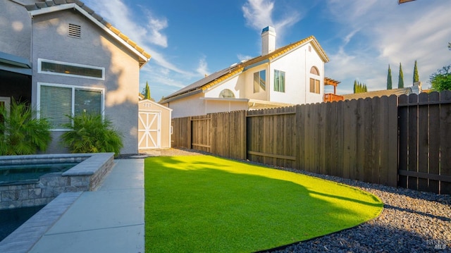 view of yard with a pool and a storage unit