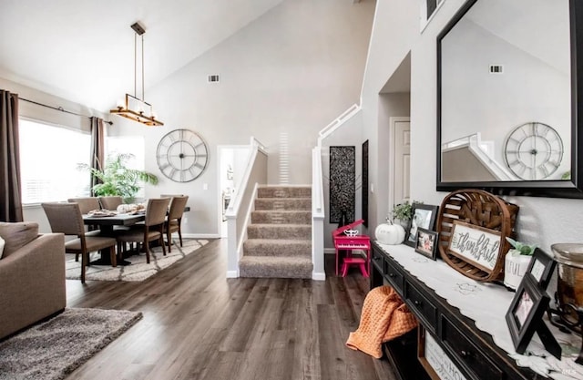 interior space featuring dark hardwood / wood-style flooring, high vaulted ceiling, and a chandelier