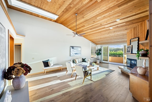 living room with vaulted ceiling with skylight, ceiling fan, wood ceiling, and hardwood / wood-style floors