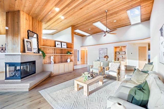 living room with a multi sided fireplace, wooden ceiling, and light hardwood / wood-style floors