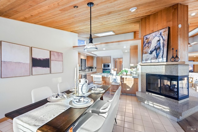 dining area with a multi sided fireplace, light tile patterned floors, and wooden ceiling