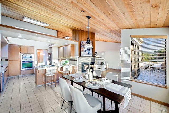 tiled dining room featuring vaulted ceiling with skylight and wooden ceiling