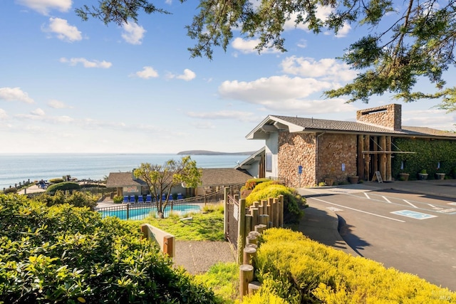 exterior space with a water view and a fenced in pool