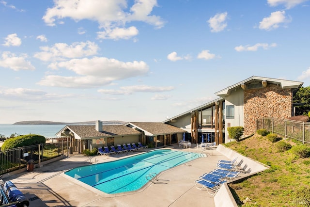 view of swimming pool with a patio area and a water view