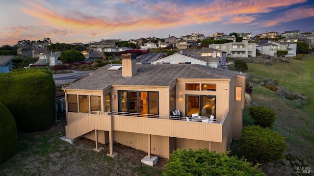 back house at dusk with a balcony