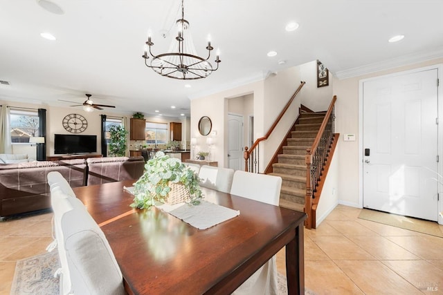 tiled dining area with ornamental molding and ceiling fan with notable chandelier