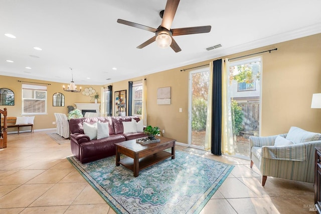 living room featuring ornamental molding, ceiling fan with notable chandelier, and light tile patterned flooring