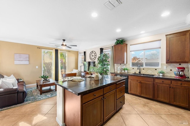 kitchen featuring sink, backsplash, plenty of natural light, and black dishwasher