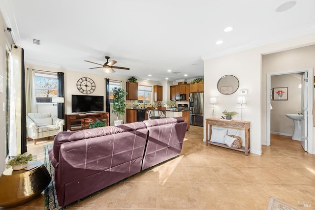 tiled living room featuring ornamental molding and ceiling fan