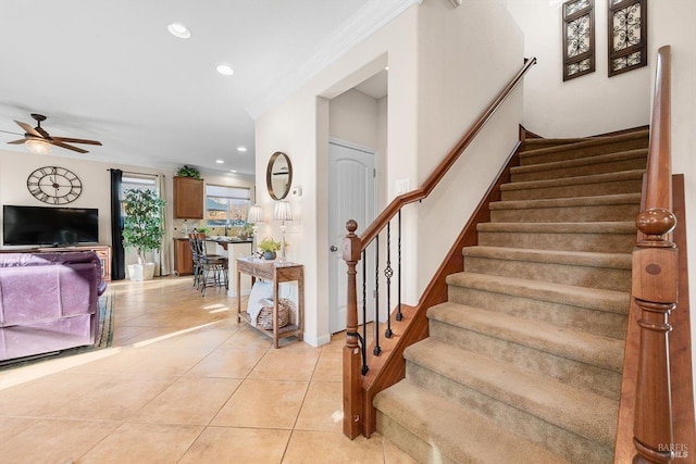 staircase featuring crown molding, ceiling fan, and tile patterned flooring