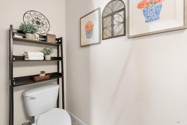 bathroom with baseboards and toilet