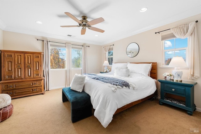 bedroom with ceiling fan, ornamental molding, and light carpet