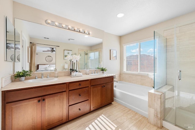 bathroom featuring shower with separate bathtub and vanity