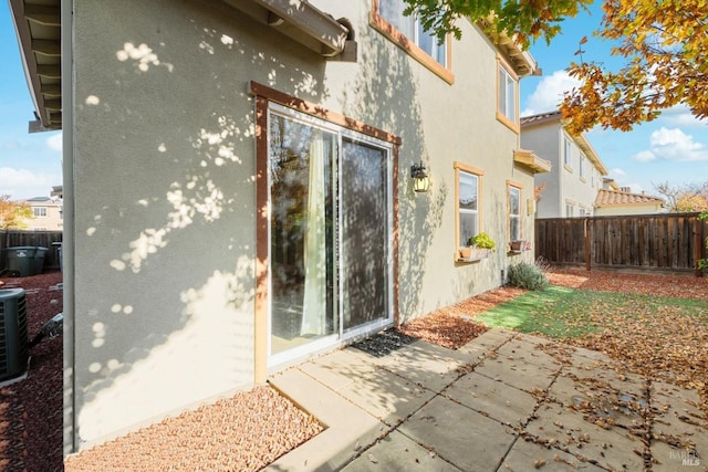 view of side of home with a patio area and central air condition unit