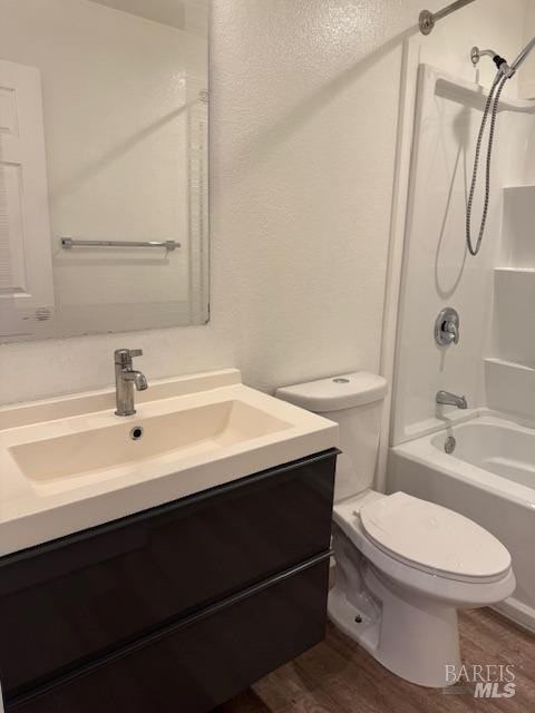 full bathroom featuring toilet,  shower combination, wood-type flooring, and vanity