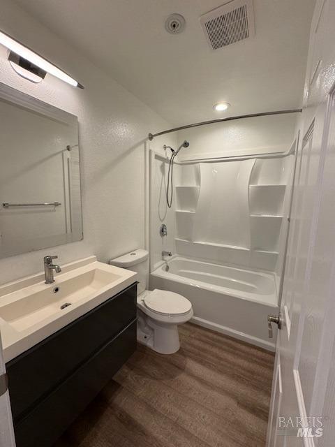 full bathroom featuring tub / shower combination, hardwood / wood-style floors, toilet, and vanity