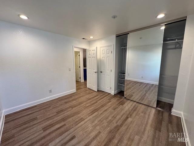 unfurnished bedroom featuring dark hardwood / wood-style flooring