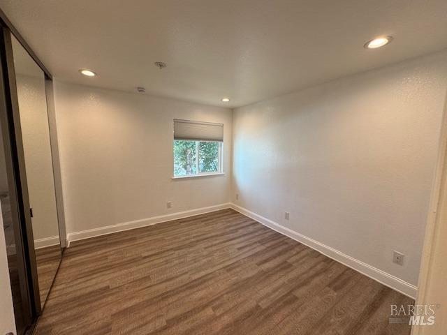 empty room with dark wood-type flooring