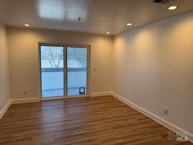 spare room featuring dark wood-type flooring