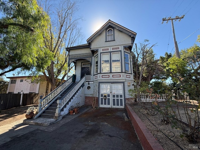 victorian house with stairs and fence