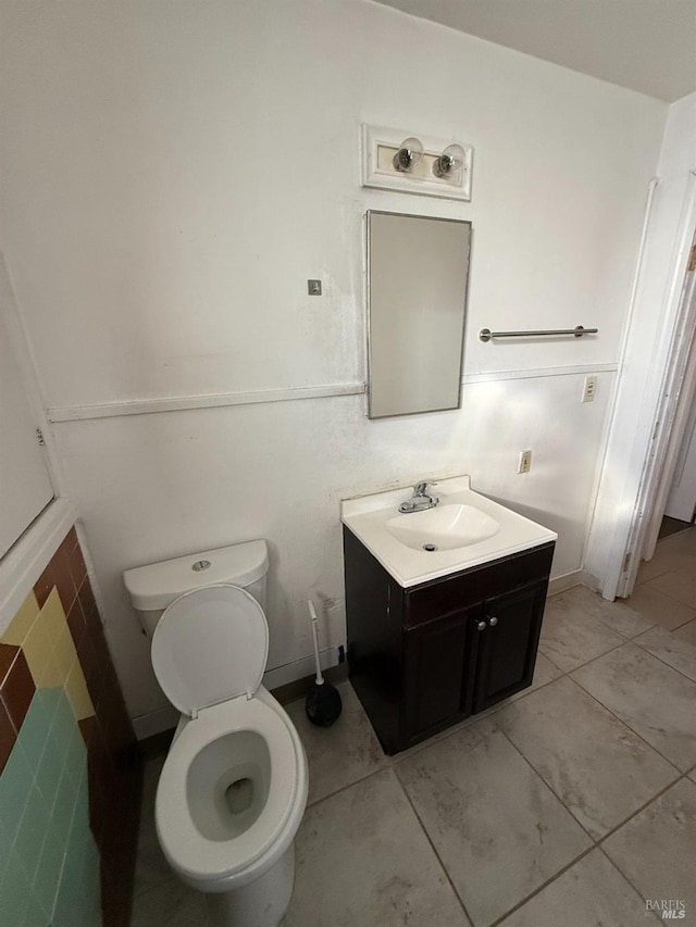 bathroom with toilet, tile patterned floors, and vanity