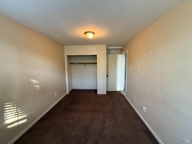 unfurnished bedroom featuring a closet, carpet, and baseboards