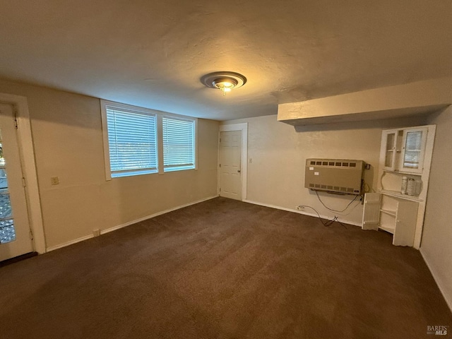 empty room with baseboards, dark colored carpet, and heating unit