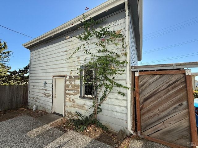 view of side of home featuring fence