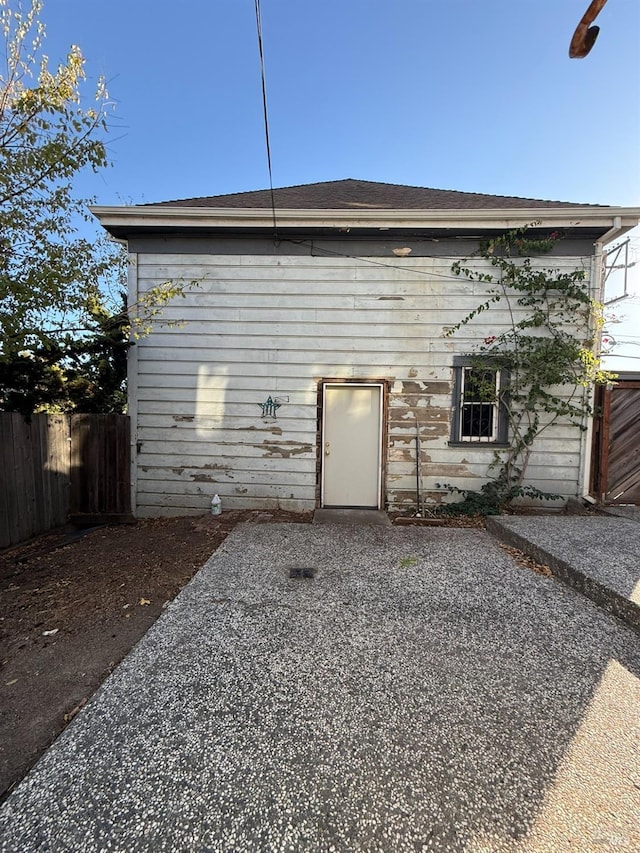 rear view of house featuring a patio and fence