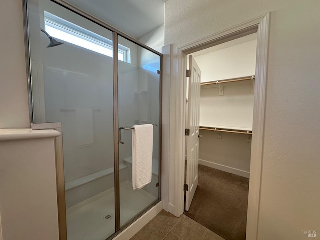 bathroom with tile patterned flooring and a shower with shower door