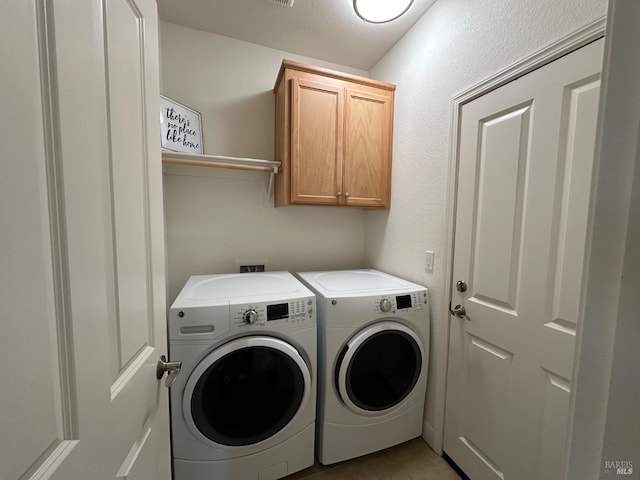 laundry room with cabinets and washing machine and clothes dryer