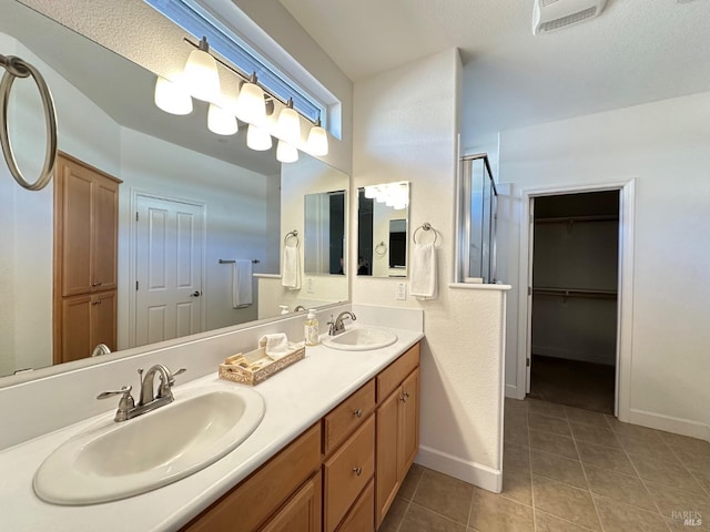 bathroom featuring tile patterned flooring, a textured ceiling, and vanity