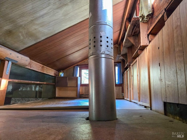 bonus room featuring vaulted ceiling and wood walls