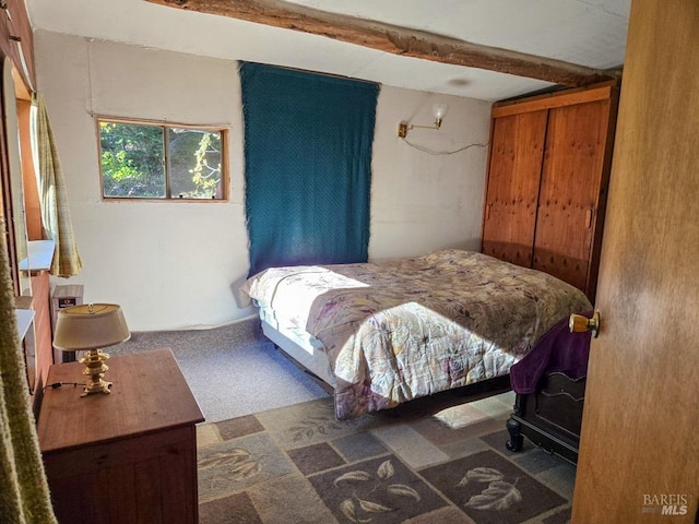 bedroom featuring carpet floors and beam ceiling