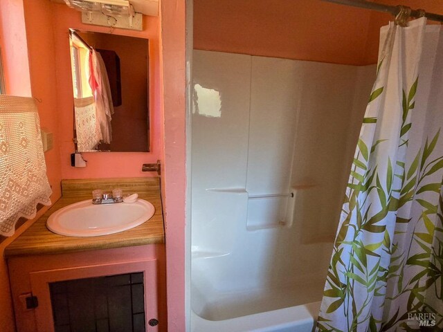 bathroom featuring vanity and shower / tub combo with curtain