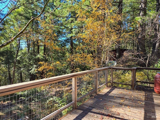 wooden terrace with a view of trees