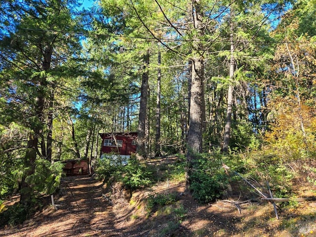 exterior space with an outdoor structure and a view of trees