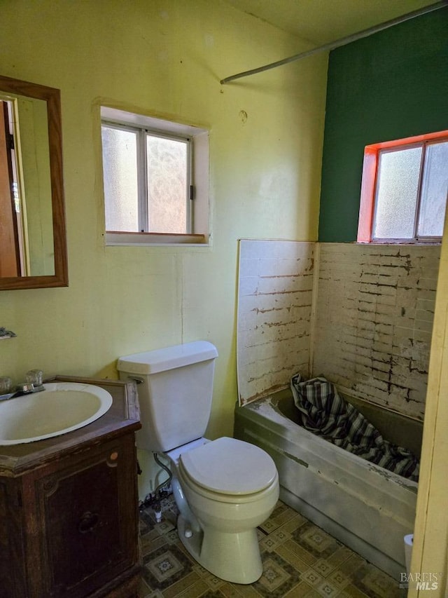 full bathroom with toilet, tile patterned floors, a bathtub, and vanity