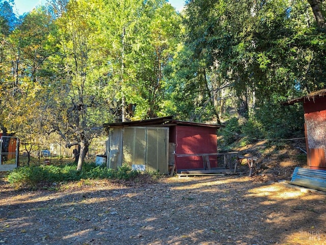 view of outbuilding featuring an outdoor structure and a view of trees