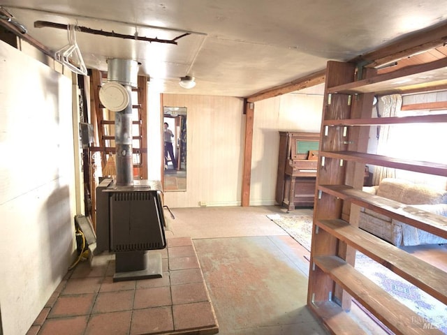 below grade area featuring a wood stove and wood walls