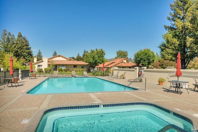 pool with a patio area and fence