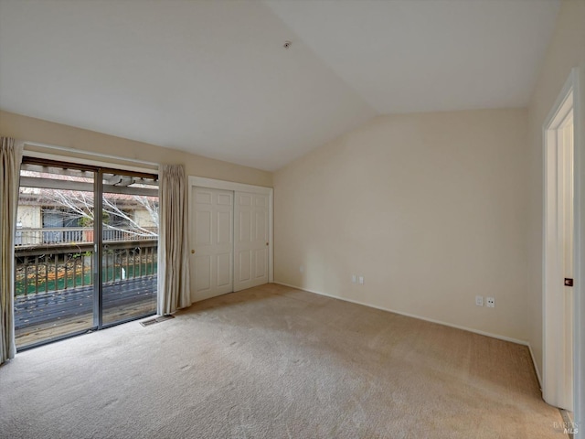 unfurnished bedroom with visible vents, a closet, vaulted ceiling, access to exterior, and carpet flooring