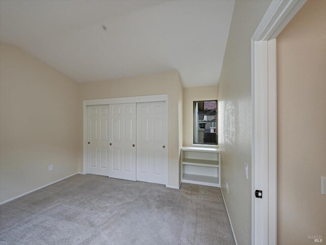 unfurnished bedroom with a closet, carpet flooring, and baseboards