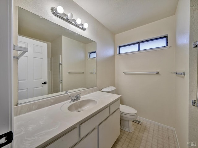 bathroom featuring vanity, visible vents, baseboards, and toilet