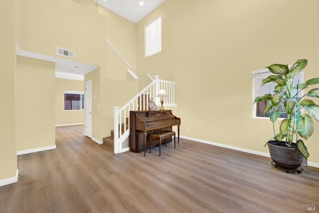 interior space featuring hardwood / wood-style floors and a towering ceiling