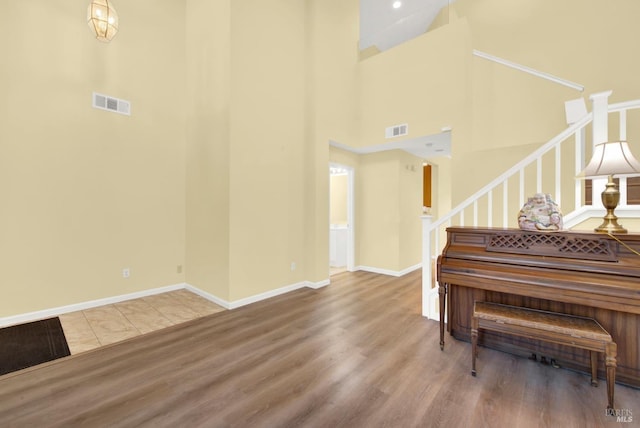 foyer entrance with hardwood / wood-style floors and a towering ceiling